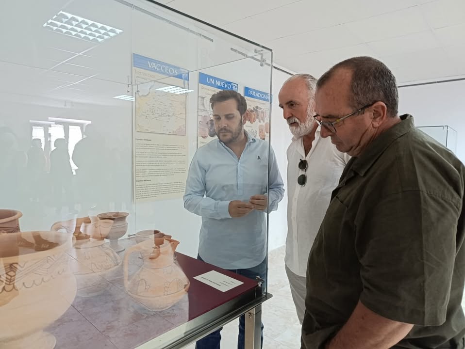 Tres personas observando cerámica en la exposición Vacceos en Zamora