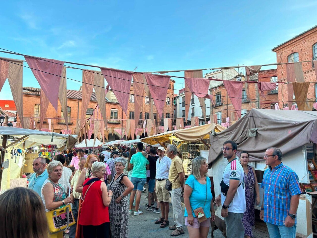 Visitantes disfrutando del Mercado Medieval en Benavente con decoraciones festivas