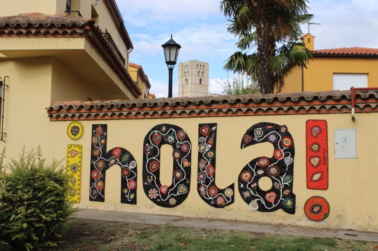 Mosaico colorido que dice ¡Hola! en la calle Mediodía