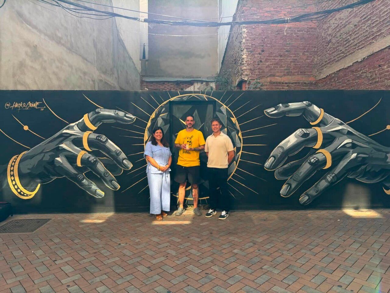 Mural en Benavente dedicado al eclipse solar con tres personas posando.