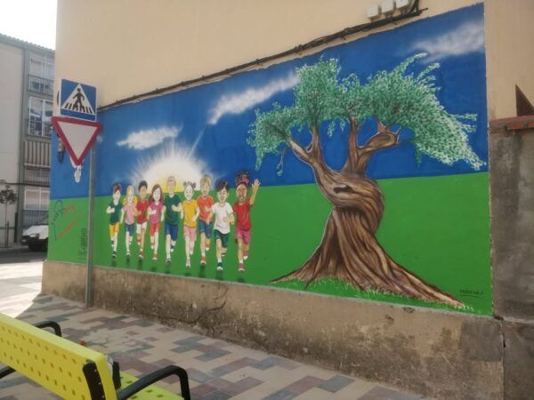 Mural infantil colorido en el colegio Nuestra Señora del Rocío con niños corriendo.