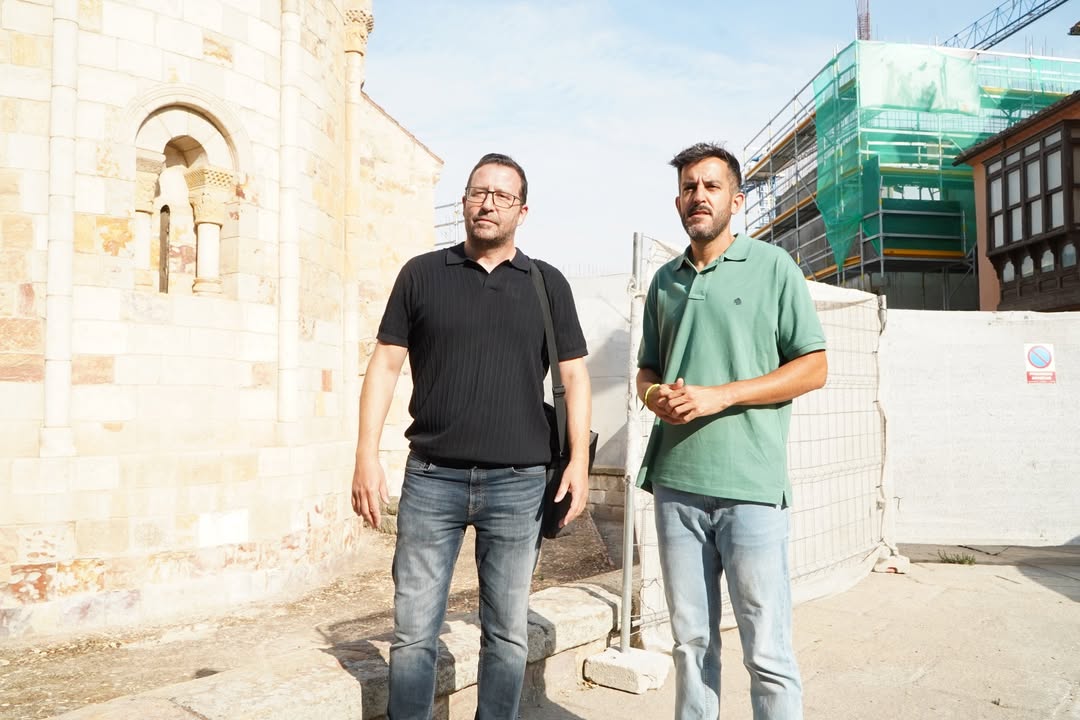 Dos hombres de pie frente a un edificio en construcción en Zamora
