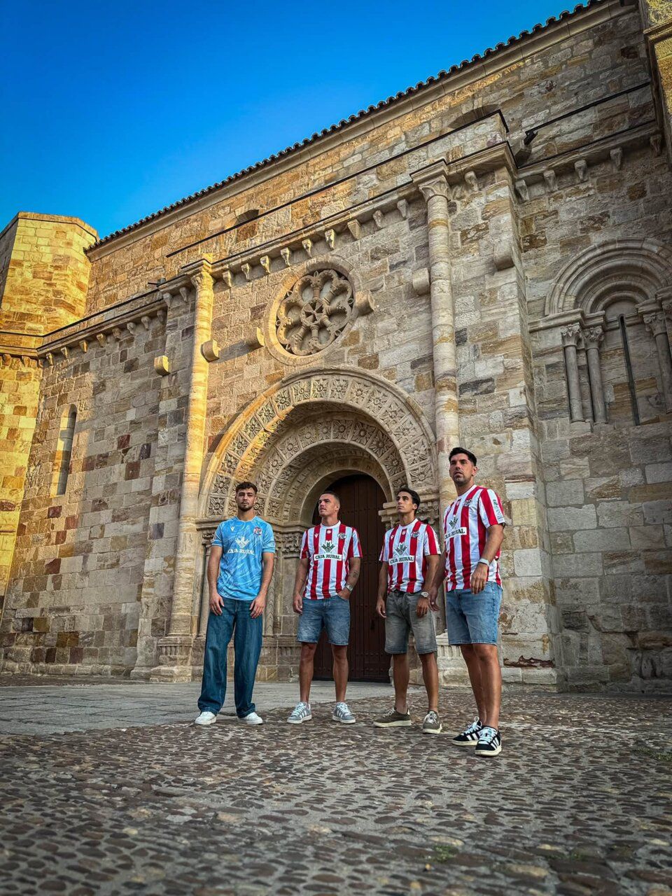 Jugadores del Zamora CF posando con nuevas camisetas frente a un edificio histórico