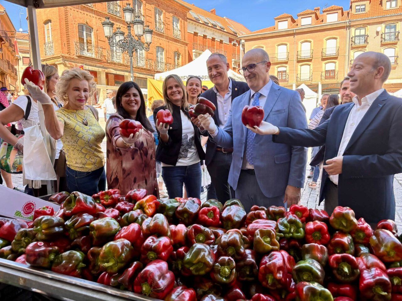 Participantes sosteniendo pimientos en la Feria del Pimiento en Benavente