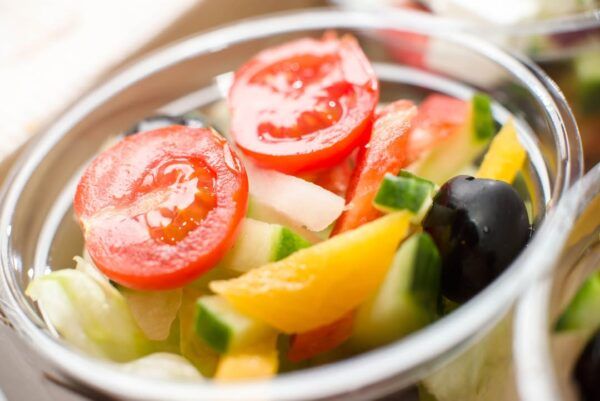 Ensalada fresca con tomate, pepino y pimientos en un recipiente