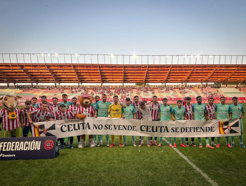 Jugadores de fútbol en Ceuta sosteniendo una pancarta de defensa de la identidad local