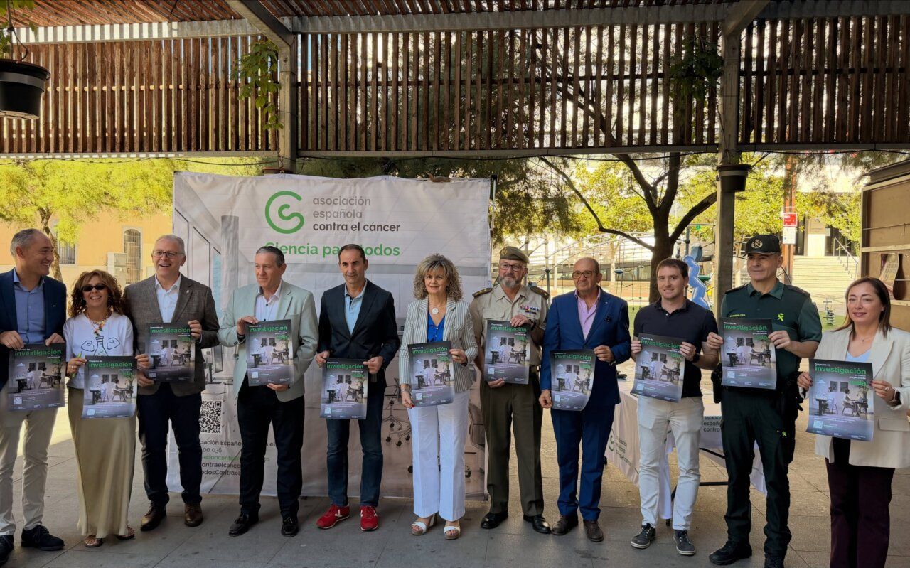 Grupo de personas sosteniendo carteles en un evento de la Asociación Española Contra el Cáncer.