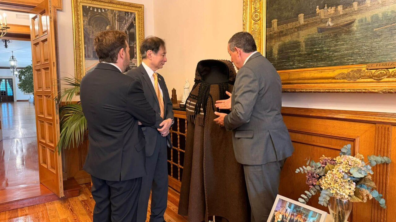 Tres hombres conversando en una sala con decoración elegante