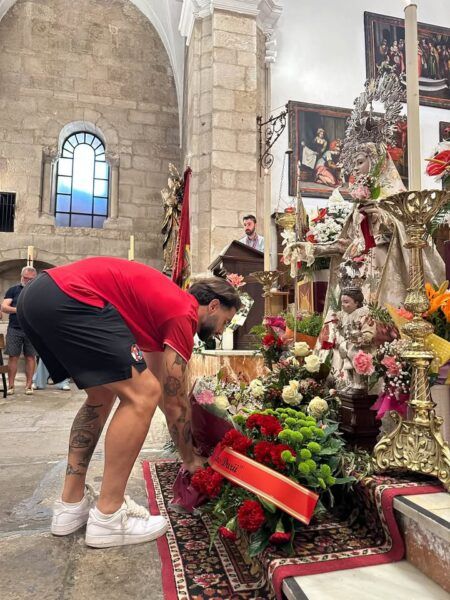 Jugador del Zamora Club de Fútbol colocando flores a La Virgen de la Concha
