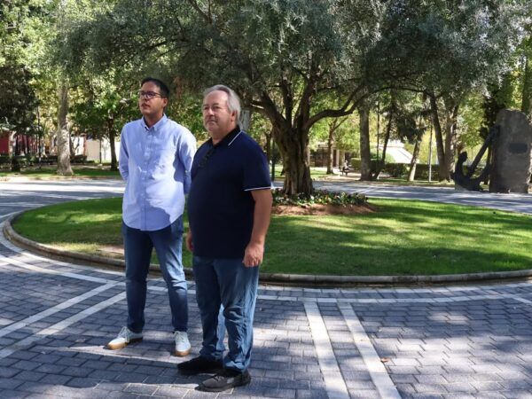Dos hombres en la plaza de la Marina en Zamora, rodeados de vegetación.