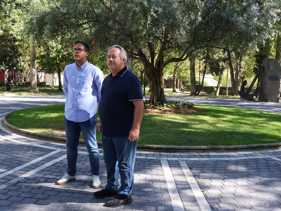 Dos hombres en la plaza de la Marina en Zamora, rodeados de vegetación.