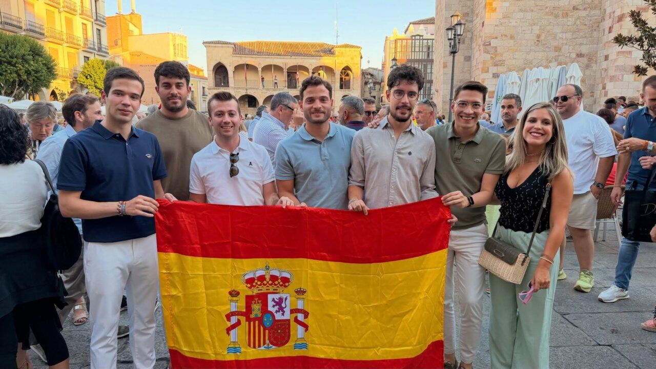 Grupo de personas sosteniendo una bandera de España en la Plaza Mayor de Zamora.