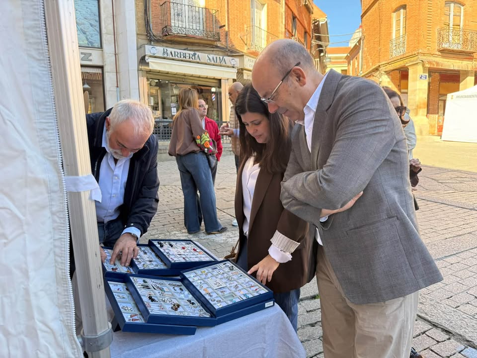 Inauguración de la Feria del Pequeño Comercio en Benavente con asistentes observando productos