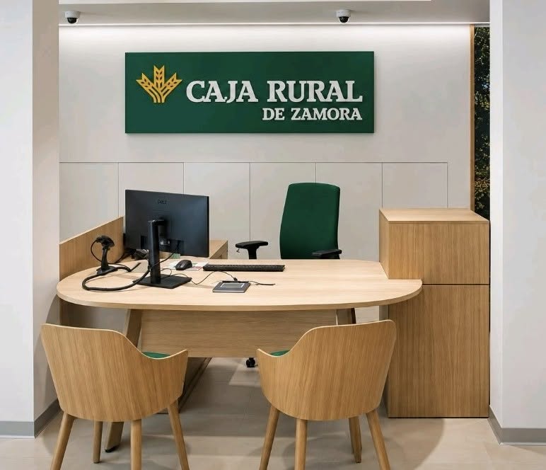 Mostrador de atención con sillas, ordenador y rótulo de Caja Rural de Zamora