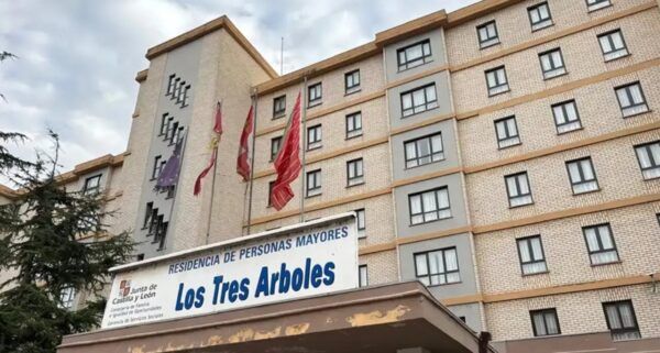Fachada de la residencia de personas mayores Los Tres Árboles, con varias banderas.