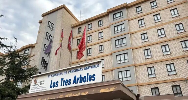 Fachada de la residencia de personas mayores Los Tres Árboles, con varias banderas.