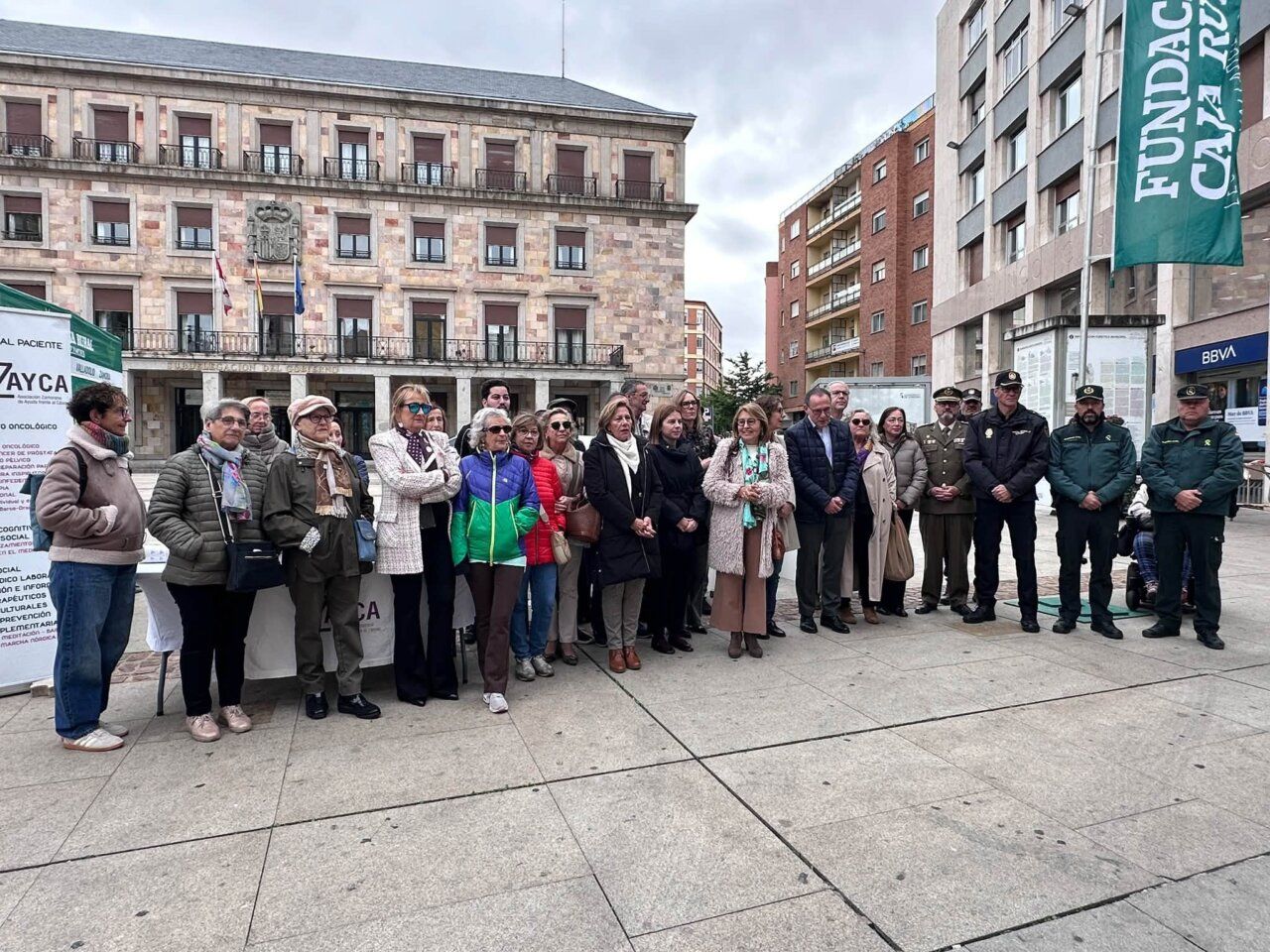 Grupo de personas posa en una plaza junto a carteles de AZAYCA.