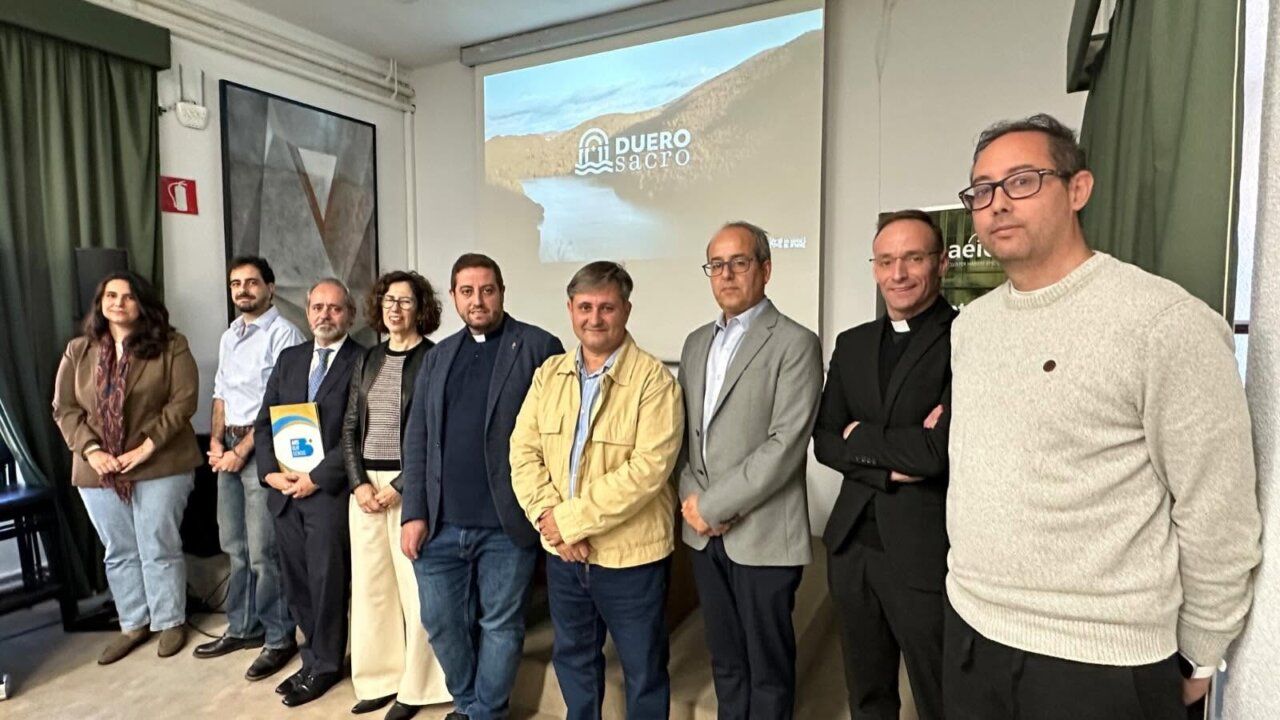 Grupo de personas posa en una sala bajo una proyección con el logotipo Duero Sacro
