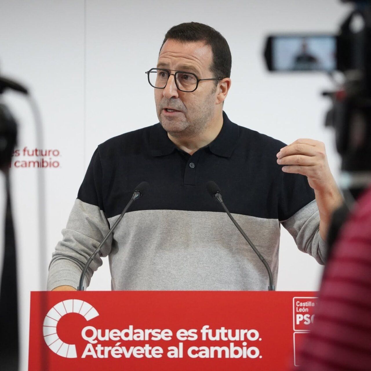 Hombre con gafas habla ante un atril del PSOE de Castilla y León.