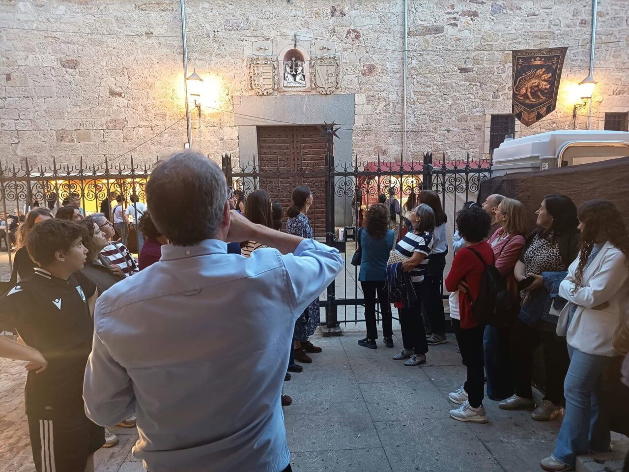 Un grupo se reúne ante la portada de piedra de la iglesia de La Magdalena.