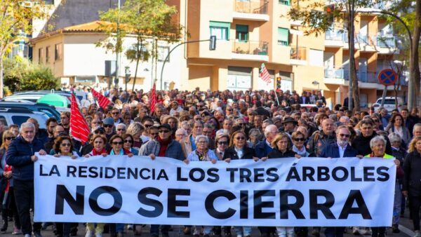 Manifestantes sostienen una pancarta que afirma que la residencia Los Tres Árboles no se cierra.