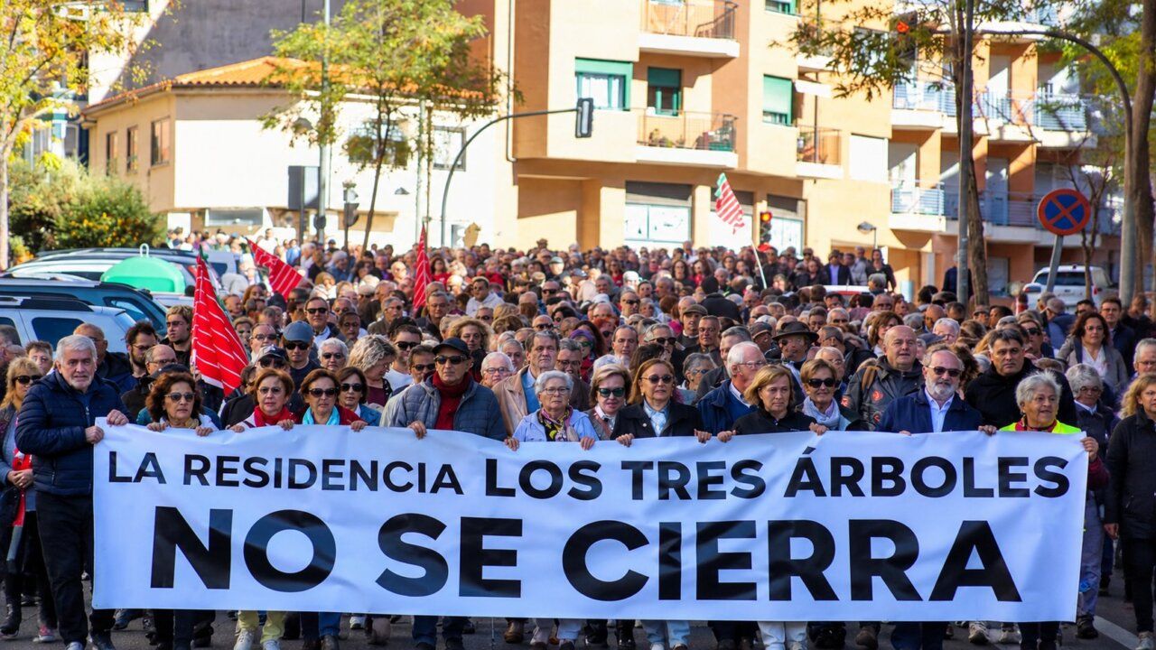 Manifestantes sostienen una pancarta que afirma que la residencia Los Tres Árboles no se cierra.
