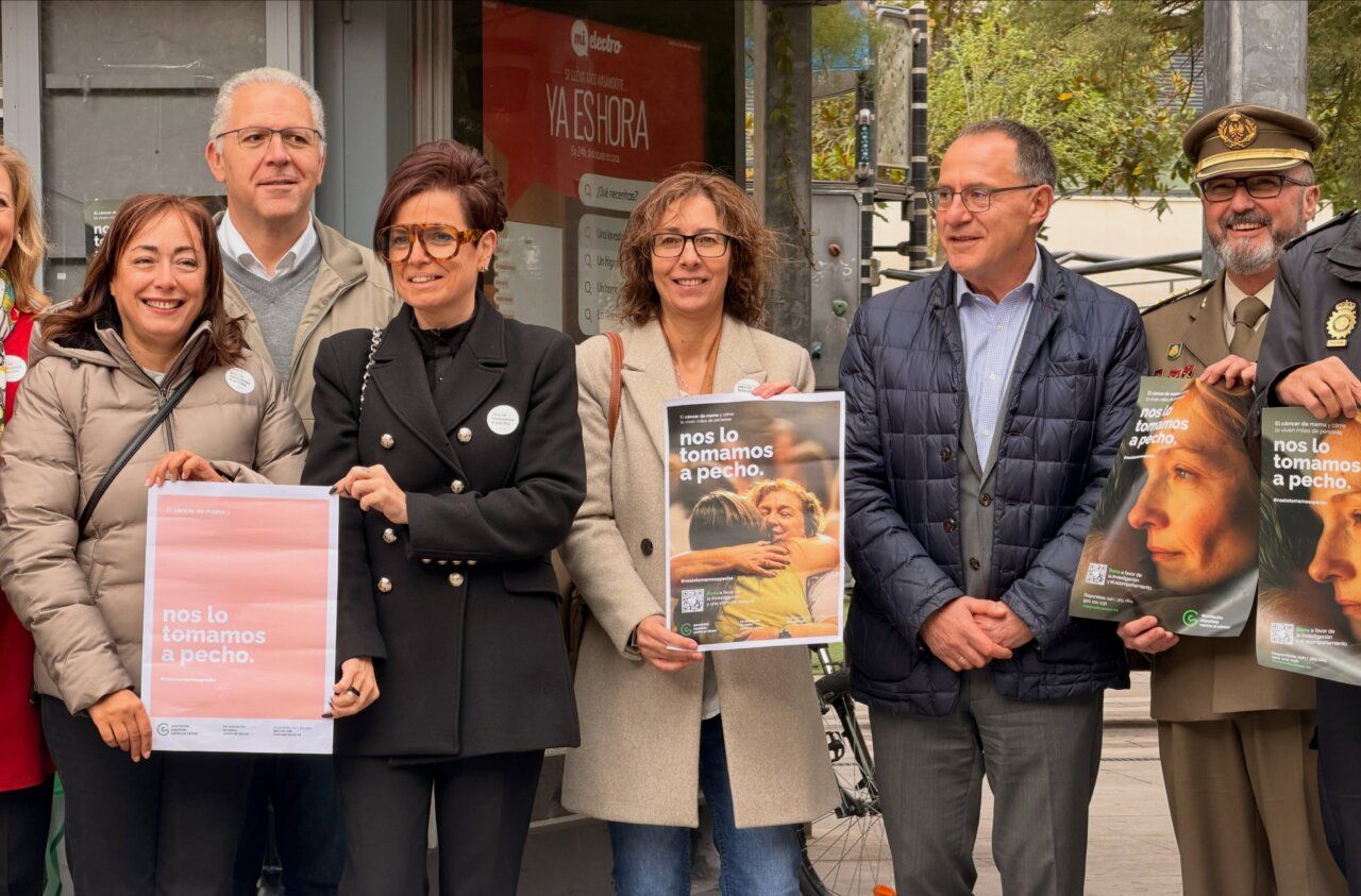 Varias personas sostienen carteles de una campaña de concienciación sobre el cáncer de mama.