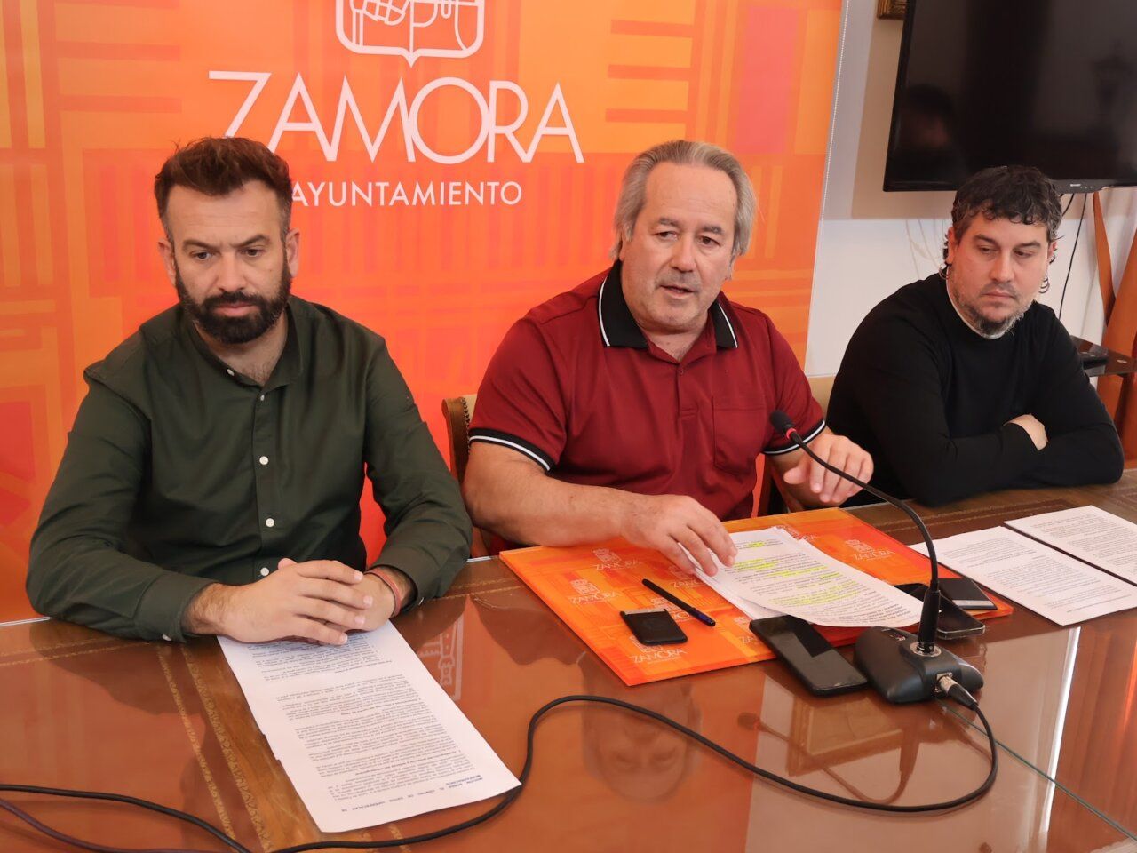 Tres hombres sentados ante documentos en una mesa del Ayuntamiento de Zamora