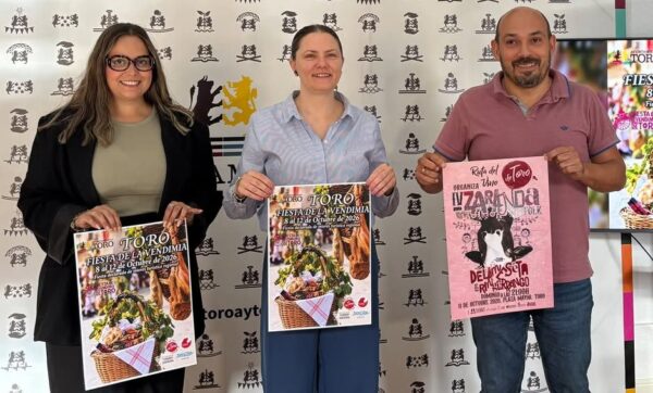 Tres personas sosteniendo carteles de la Fiesta de la Vendimia en Toro