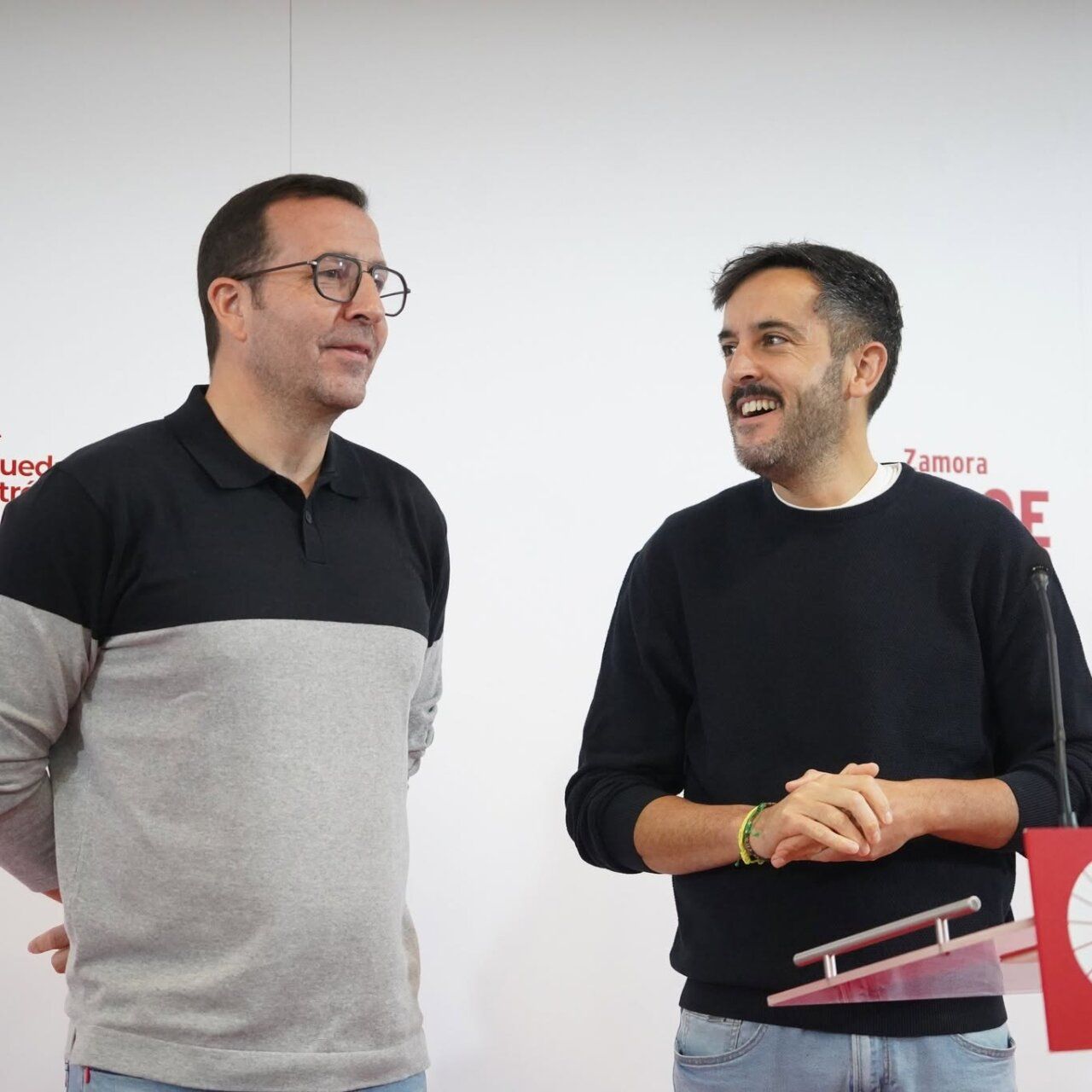 Dos hombres junto a un atril ante un fondo con referencias al PSOE de Zamora