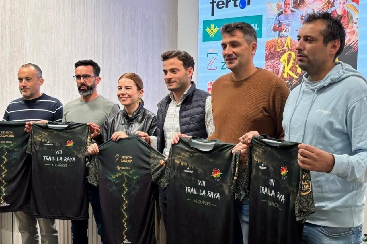 Seis personas muestran camisetas de la VIII Trail La Raya en una sala