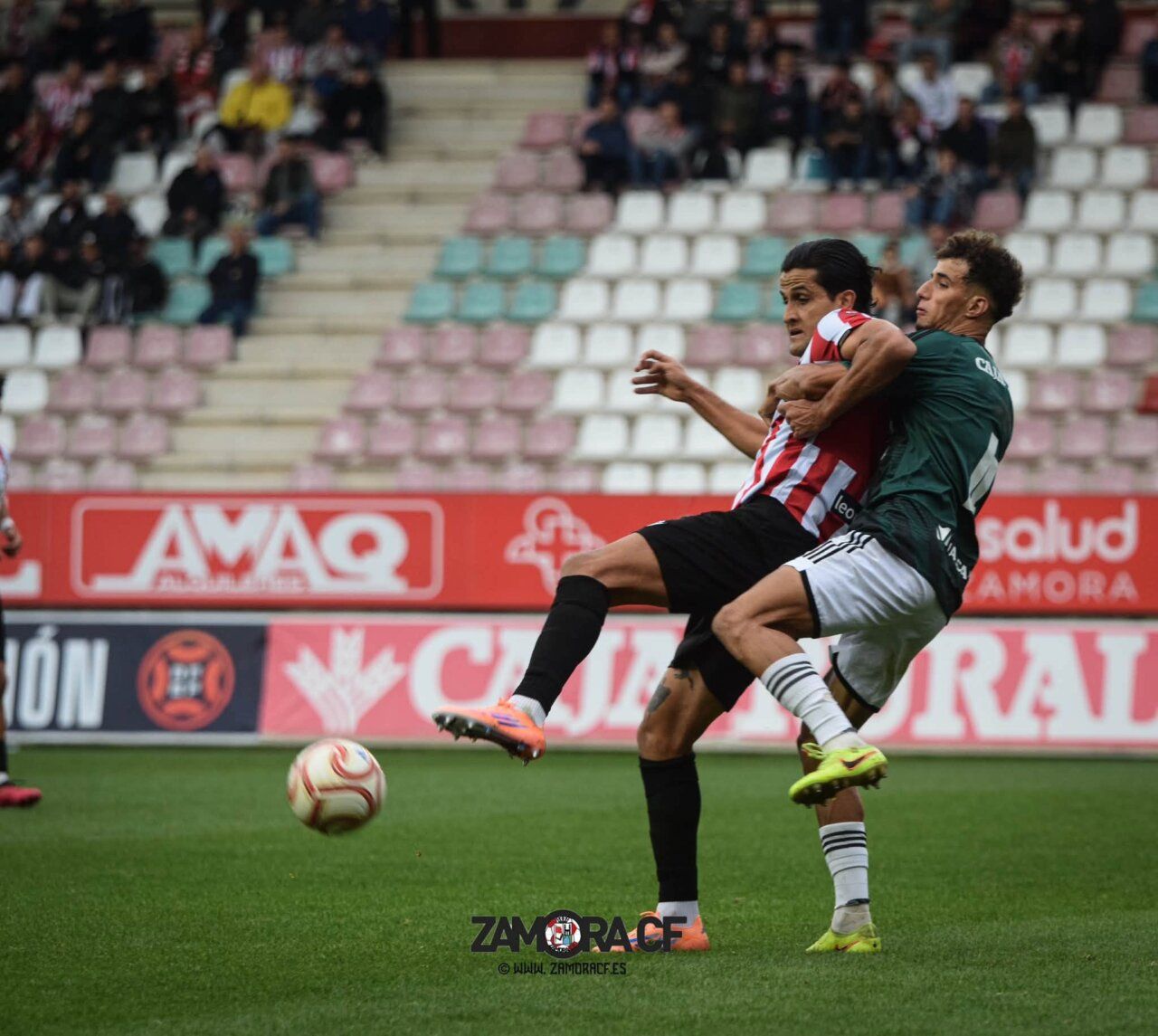 Dos jugadores disputan el balón durante un partido de fútbol en el campo