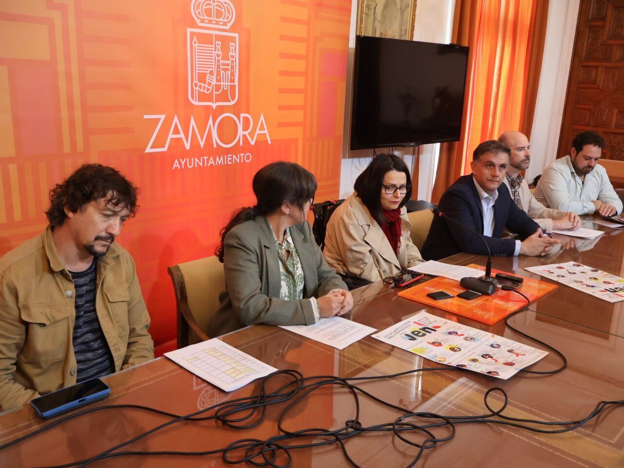 Varias personas sentadas ante una mesa con folletos del Festival JEN en Zamora.