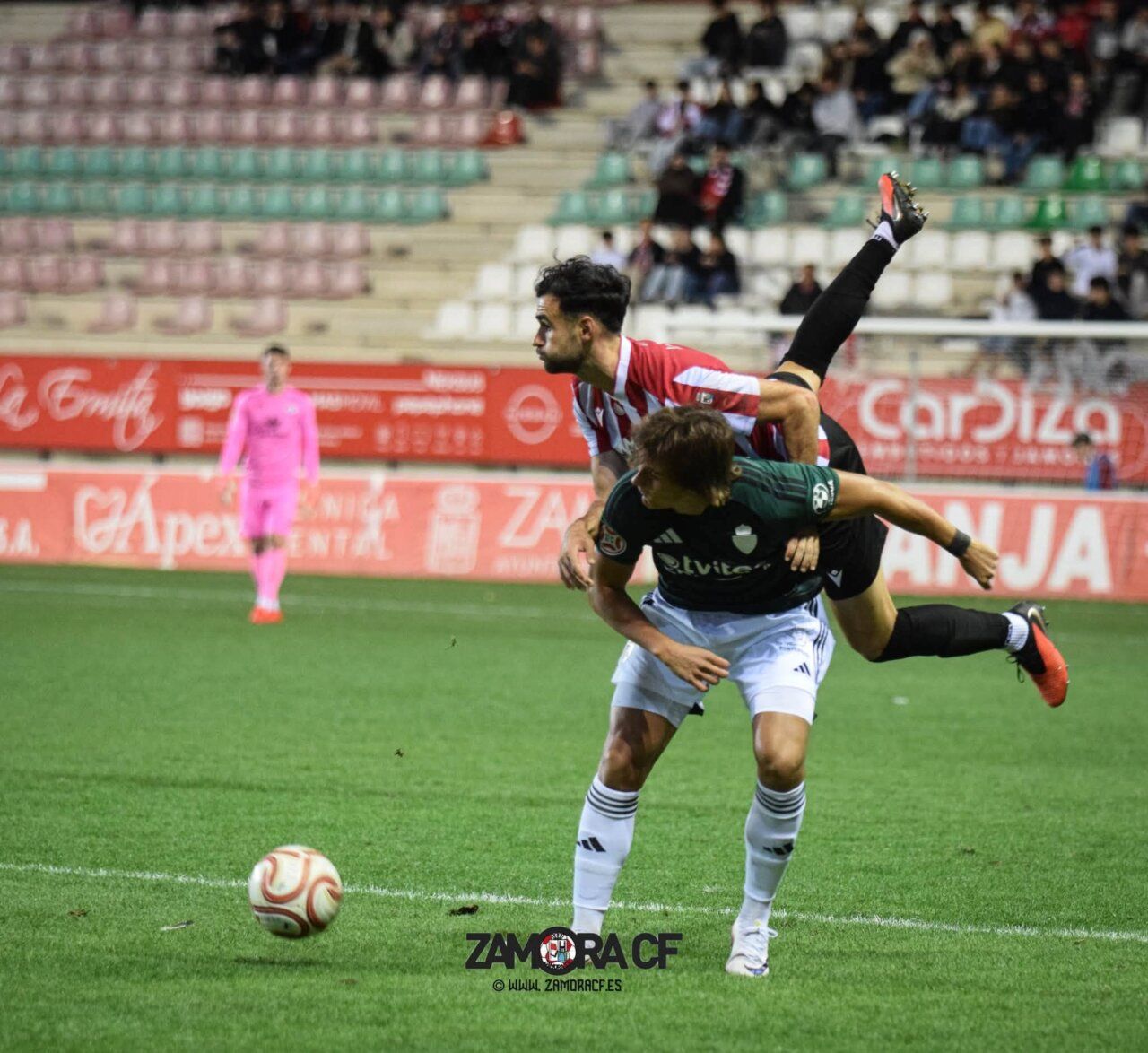 Dos futbolistas disputan el balón durante una jugada en el campo de juego